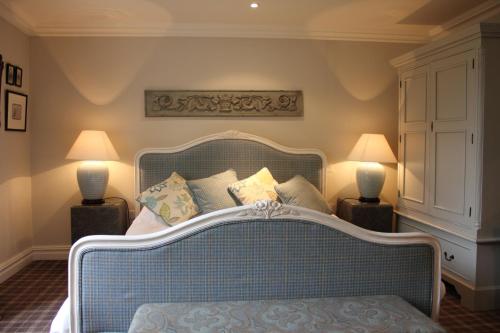 a bedroom with a bed with pillows and two lamps at The Spread Eagle in Clitheroe