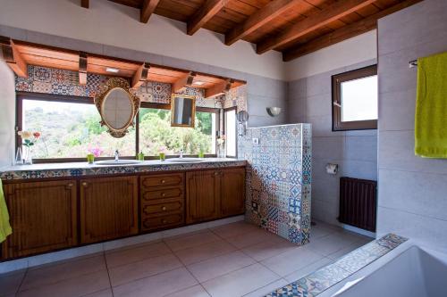 ein Badezimmer mit Waschbecken, Spiegel und Badewanne in der Unterkunft Casa Las Rocas in Santa Úrsula