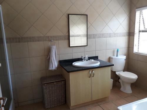 ein Bad mit einem Waschbecken und einem WC in der Unterkunft The Shore's in Southbroom