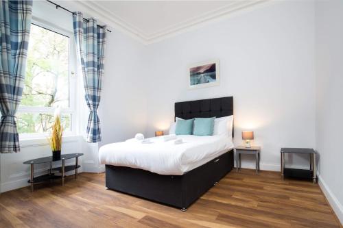 una camera con un grande letto e una finestra di Montgomery Central Apartment a Edimburgo