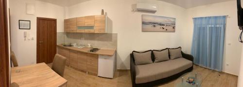 a kitchen with a couch and a table in a room at Apartmani Gaga in Tivat