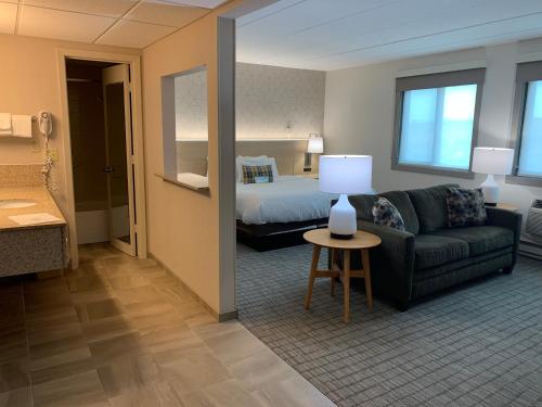 a hotel room with a bed and a couch at Days Inn & Suites by Wyndham Duluth by the Mall in Duluth