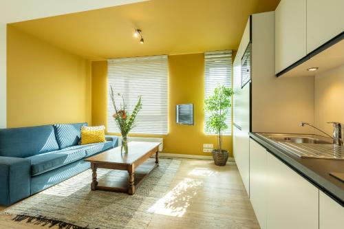 un soggiorno con un divano e un tavolo di SHWAY - The India Yellow Studio ad Anversa