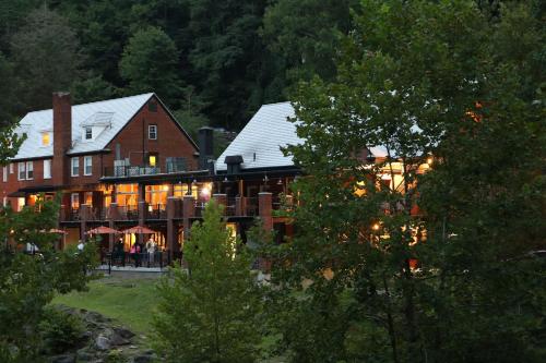 a large building with lights on in a forest at Historic Tapoco Lodge in Tapoco