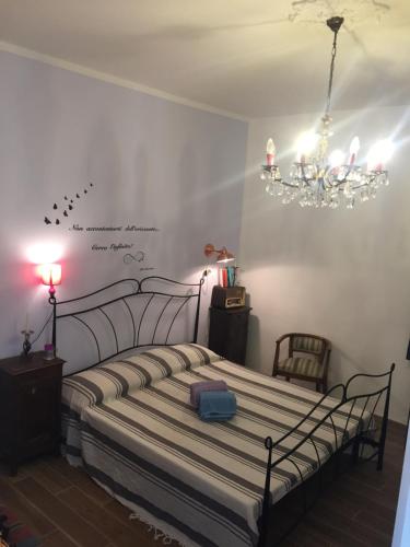 a bedroom with a bed and a chandelier at Oca Carolina in Buttigliera Alta