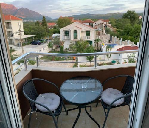 two chairs and a table on a balcony with a view at Apartmani Gaga in Tivat