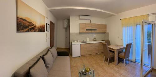 a living room and kitchen with a couch and a table at Apartmani Gaga in Tivat