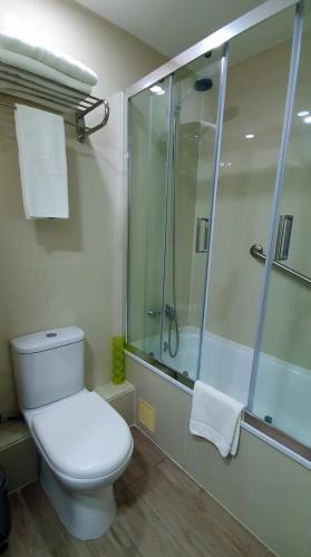 a bathroom with a toilet and a shower with towels at EcoApart Antofagasta in Antofagasta