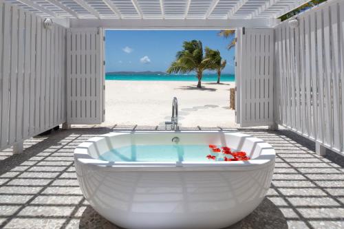 The Palm Island Resort - All Inclusive في Palm Island: حوض استحمام أبيض على الشاطئ مع إطلالة