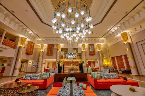 un gran vestíbulo con sofás rojos y una lámpara de araña en Continental Hotel Hurghada, en Hurghada