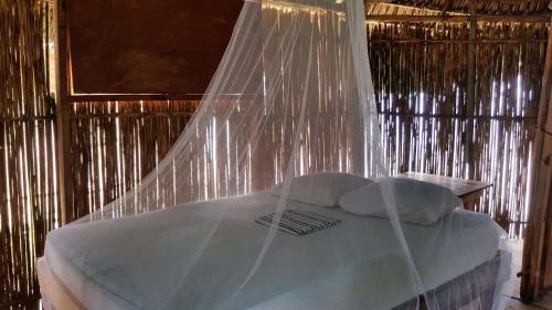 a bed with mosquito netting over it in a room at San Blas Islands - Private Cabin Over-the-Ocean including Meals in Mandinga