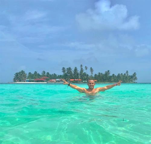 a man in the ocean with his arms outstretched at San Blas Islands - Private Cabin Over-the-Ocean including Meals in Mandinga