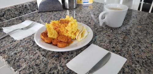 a plate of food on a table with a cup of coffee at Pousada Azevedo in Livramento de Nossa Senhora