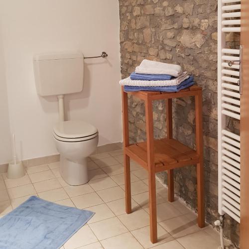 a bathroom with a toilet and a table with towels at Casa Re - B&B e Vino a Montabone in Montabone