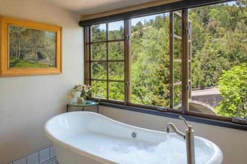 y baño con bañera y ventana grande. en Benbow Historic Inn en Garberville