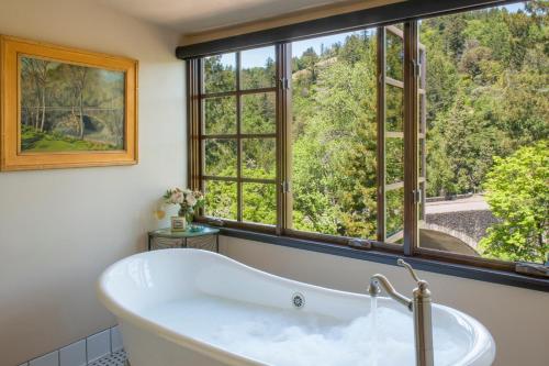 eine Badewanne im Bad mit einem großen Fenster in der Unterkunft Benbow Historic Inn in Garberville