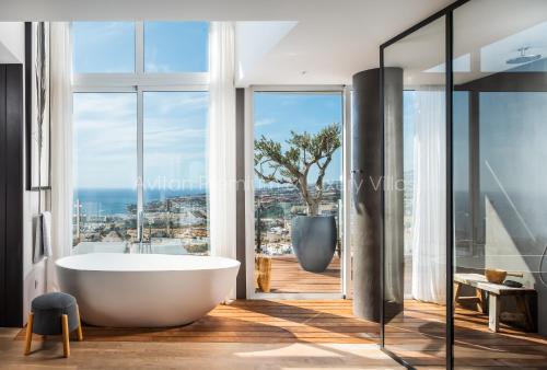 a bathroom with a tub and a view of the ocean at Avitan Premium & Luxury Villas in Adeje