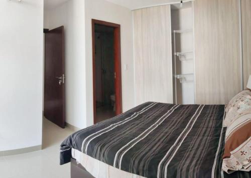um quarto com uma cama e uma porta para um armário em Atlantis Towers Apartamento em Santa Cruz de la Sierra
