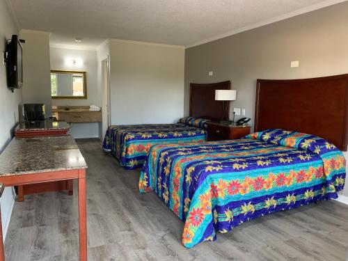 una camera d'albergo con due letti e un tavolo di Motel 6 Newport News, VA – Fort Eustis a Newport News