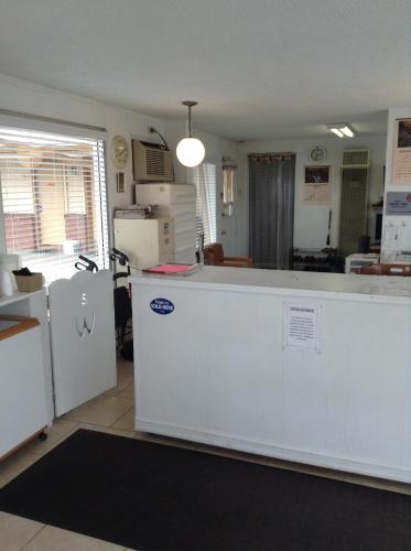 a kitchen with a white counter and a refrigerator at Ski's Western Motel in Great Falls