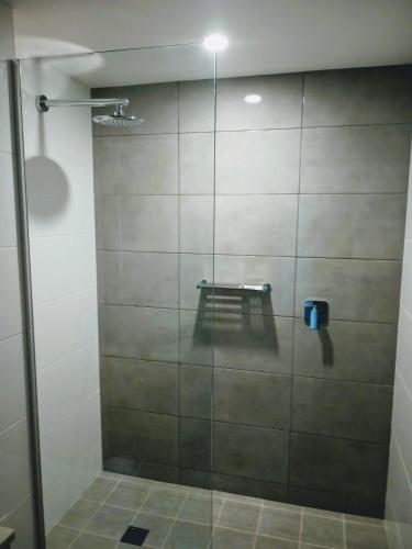 a shower with a glass door in a bathroom at Winning Post Motor Inn in Mudgee