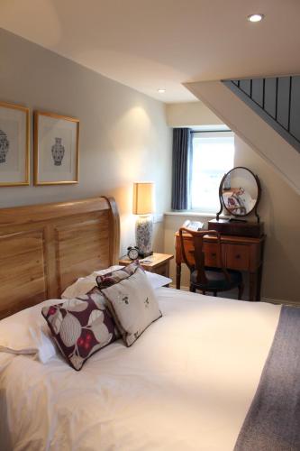 a bedroom with a bed and a desk and a window at The Spread Eagle in Clitheroe