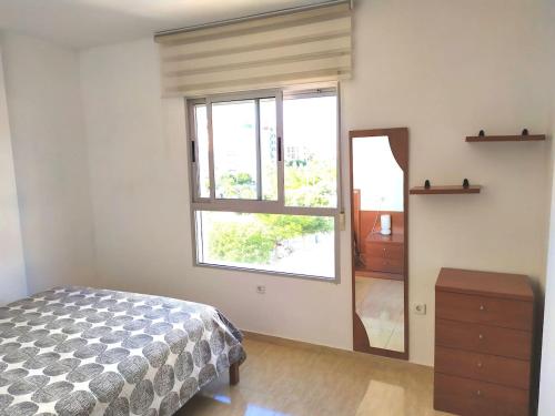 um quarto com uma cama, uma janela e uma cómoda em Apartamento Florencia em Múrcia