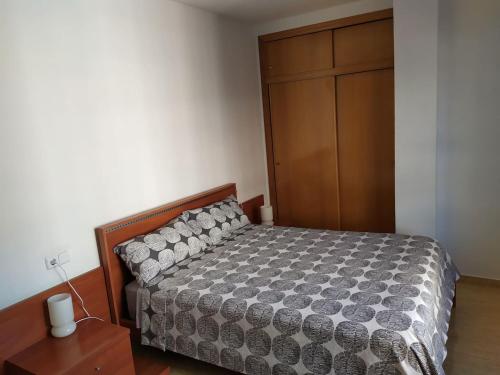 um quarto com uma cama e um armário de madeira em Apartamento Florencia em Múrcia