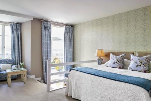 a bedroom with a bed and a chair and a window at Greenmount House in Dingle