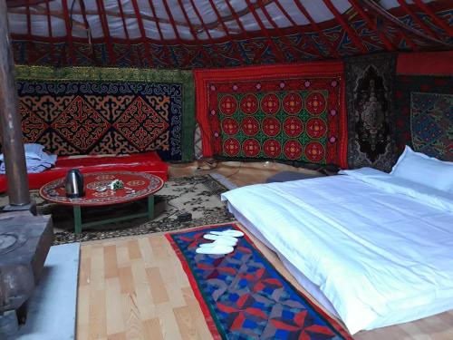 a bedroom with a bed and a table at Ger ,Bulbul Jamak travel in Ölgiy