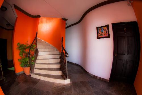 a staircase in a room with orange walls and a door at Hostal Casa de Grethel in Flores
