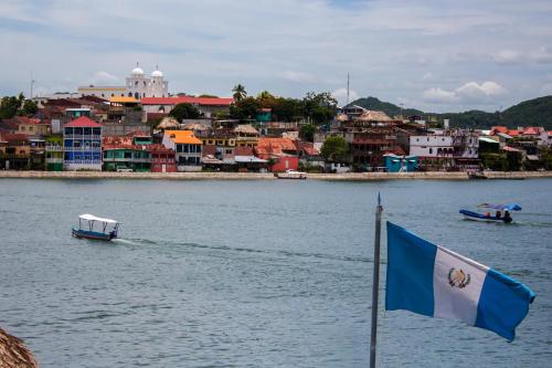 a blue and white flag on the water next to a city at Hostal Casa de Grethel in Flores