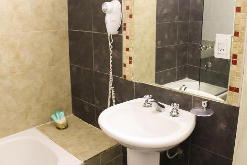a bathroom with a sink and a mirror at Savannah Cordoba Hotel in Córdoba