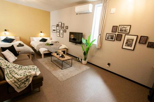 a living room with a bed and a couch at Hotel Ekolu in Sapporo