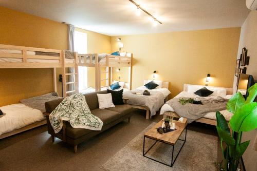 札幌市にあるUCHI Living Stay ekoluの二段ベッド2台とソファのあるリビングルーム