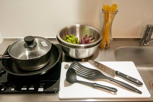 a stove with a pot and a bowl of vegetables on it at Hotel Ekolu in Sapporo
