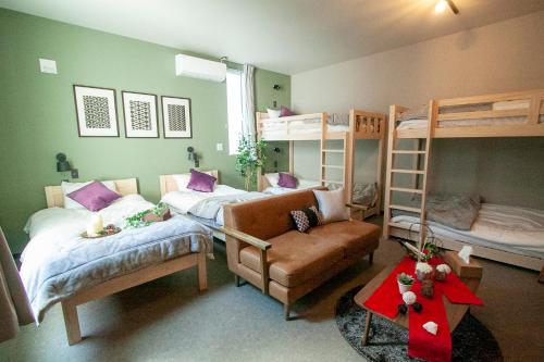 a bedroom with two bunk beds and a couch at Hotel Ekolu in Sapporo