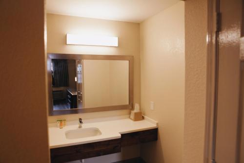 a bathroom with a sink and a mirror at All Seasons Inn & Suites in Memphis