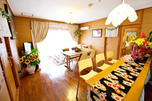 a dining room with a table and chairs and a window at Bi ONE House 2F in Yomitan