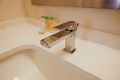 a bathroom sink with a silver faucet on a counter at All Seasons Inn & Suites in Memphis