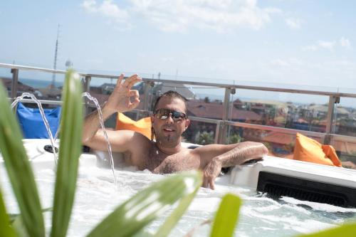 a man in a hot tub on a balcony at Zia Hotel Kuta in Kuta