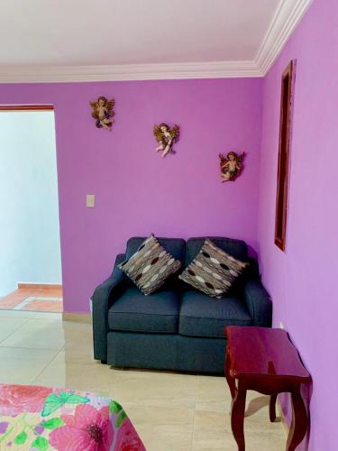 a living room with purple walls and a blue couch at Hotel Spa Maggic Home Panorámica in Guanajuato