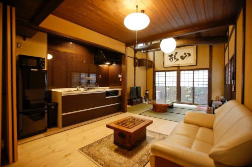 Una sala de estar con un sofá y una cocina. en Yamagata Kyomachi Hatago Nishijin, en Kioto