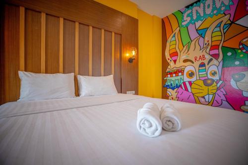 a bedroom with a large bed with towels on it at Smart Hotel in Lam Luk Ka