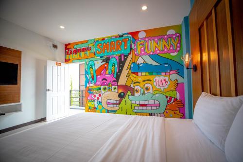 a bedroom with a bed with a mural on the wall at Smart Hotel in Lam Luk Ka