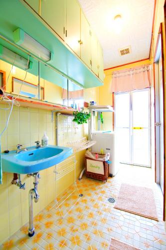 a bathroom with a blue sink and a tiled floor at Bi ONE House 2F in Yomitan