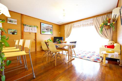 a living room with a dining room table and chairs at Bi ONE House 2F in Yomitan