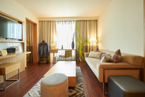 a living room with a couch and a table at Novotel Chennai OMR in Chennai