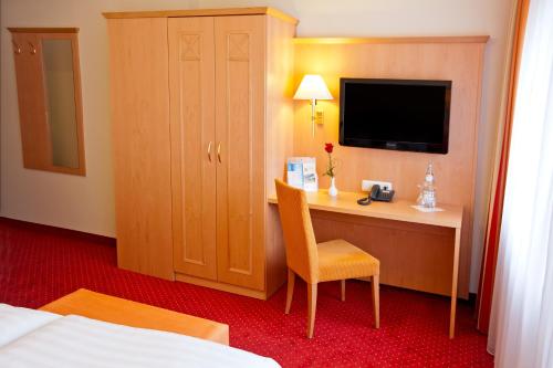 a hotel room with a desk and a television at Hotel Rosenhof in Kerpen