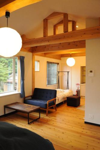 um quarto com uma cama e um sofá num quarto em WEST in em Yufu